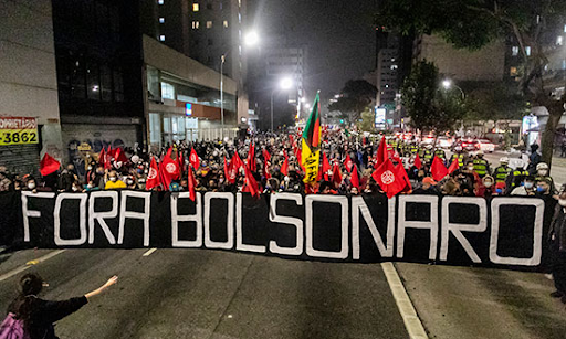 Brazilian protesters holding a sign saying "Fora Bolsonaro"